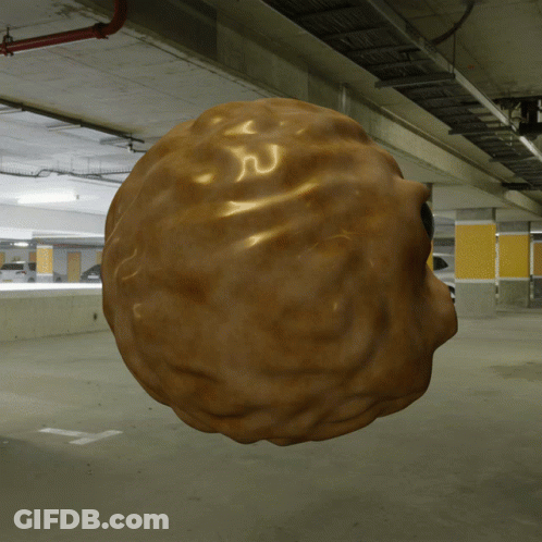 A 3D Rendering Of A Walnut Floating In A Parking Garage GIF