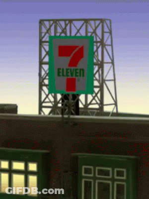 A 7 Eleven Sign On Top Of A Brick Building GIF