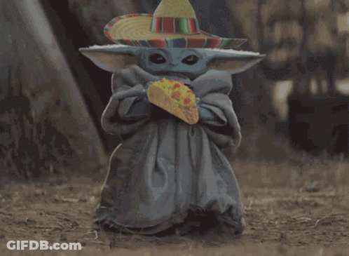 A Baby Alien Wearing A Sombrero Is Holding A Taco GIF