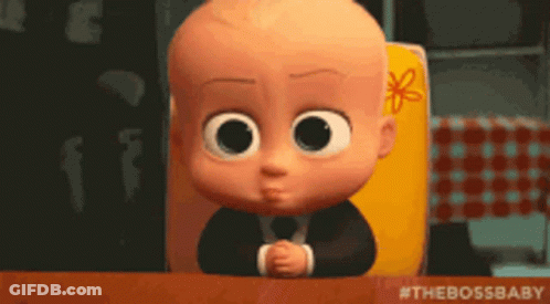 A Baby From The Boss Baby Is Sitting At A Table With His Hands Folded GIF