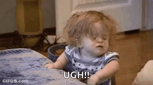 A Baby Girl Is Sitting On A Couch With Her Eyes Closed And Crying . GIF