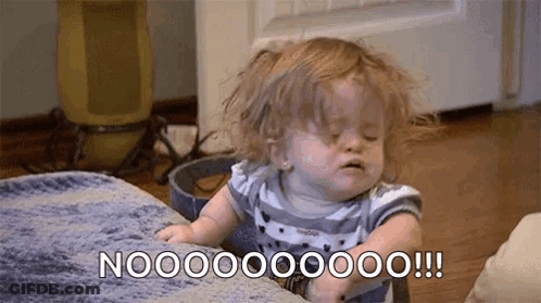 A Baby Girl Is Sitting On A Couch With Her Eyes Closed And Making A Face . GIF