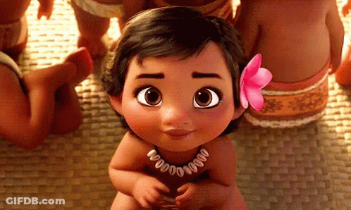 A Baby Girl With A Pink Flower In Her Hair Is Sitting On A Mat . GIF