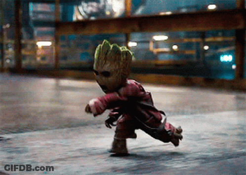 A Baby Groot Is Running Down A Street Wearing Sunglasses And A Red Jacket GIF