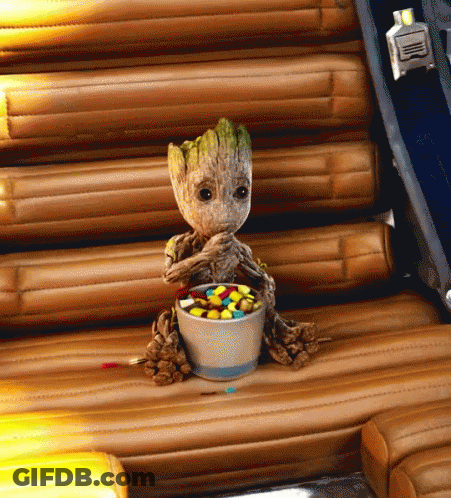 Baby Groot Eating Candy On Wooden Chair GIF