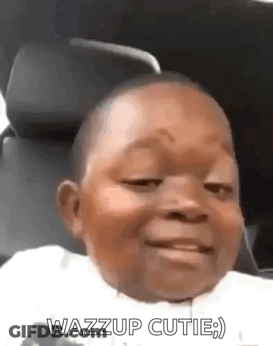 A Baby In A Car Seat With The Words Wazzup Cutie On The Bottom GIF