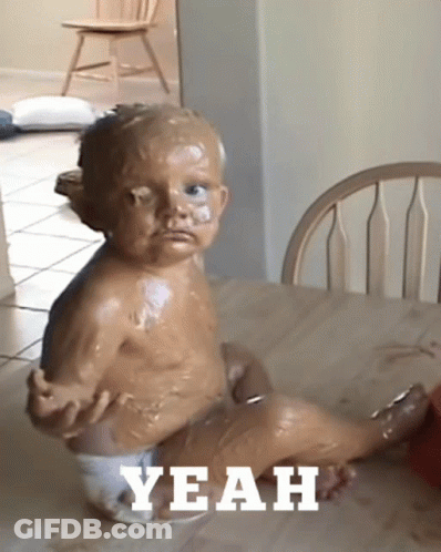 A Baby In A Diaper Is Sitting At A Table With The Word Yeah Written On The Bottom GIF