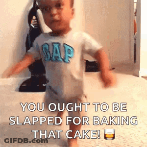 A Baby In A Gap Shirt Is Walking On A Carpet With A Glass Of Whiskey . GIF