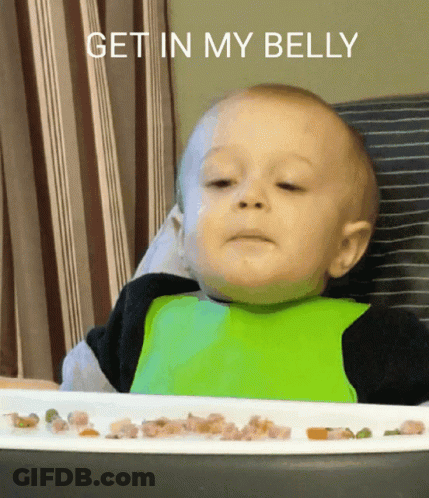 A Baby In A High Chair With A Plate Of Food And The Words Get In My Belly Above Him GIF