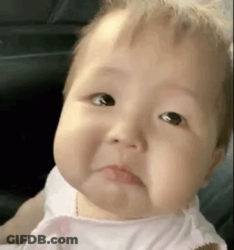 A Baby In A Pink Dress Is Making A Sad Face . GIF