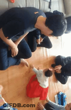 Baby In Red Dress Held By Man GIF