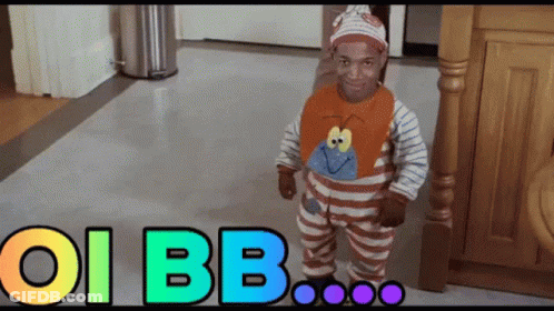 A Baby In A Striped Outfit Is Standing In Front Of A Sign That Says Oi Bb On It GIF