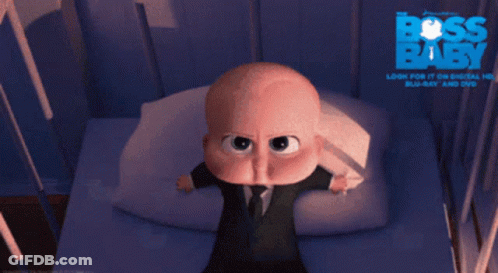 A Baby In A Suit And Tie Is Crying In Front Of A Poster That Says Boss Baby GIF