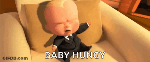 A Baby In A Suit Is Crying While Sitting On A Couch With The Words `` Baby Hungry '' . GIF
