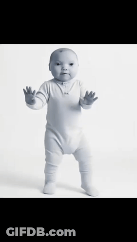 A Baby In A White Bodysuit Is Standing On Its Hind Legs GIF