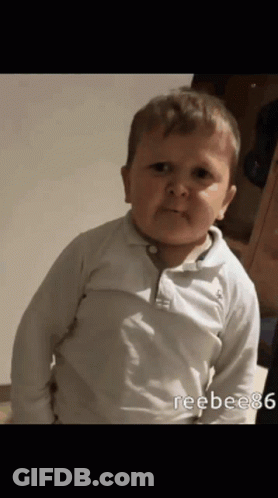 A Baby In A White Shirt Is Making A Face GIF