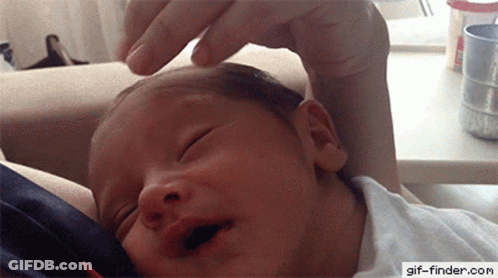 A Baby Is Being Held By A Person With A Gif-Finder.com Watermark On The Bottom Right GIF