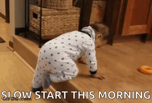 A Baby Is Crawling On A Wooden Floor With The Words Slow Start This Morning Written Below It GIF