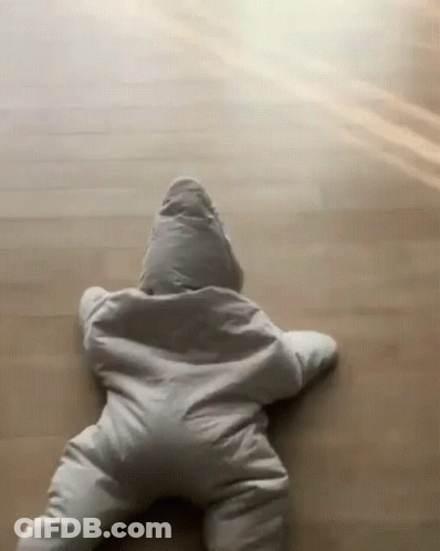 A Baby Is Crawling On The Floor Wearing A Star Shaped Outfit . GIF