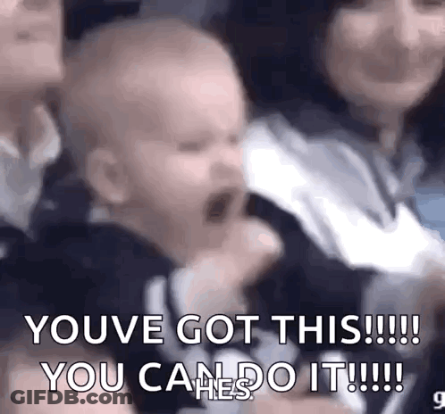 A Baby Is Crying In A Crowd Of People And A Woman Is Holding Him . GIF