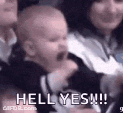 A Baby Is Crying In A Crowd Of People While A Woman Holds It . GIF