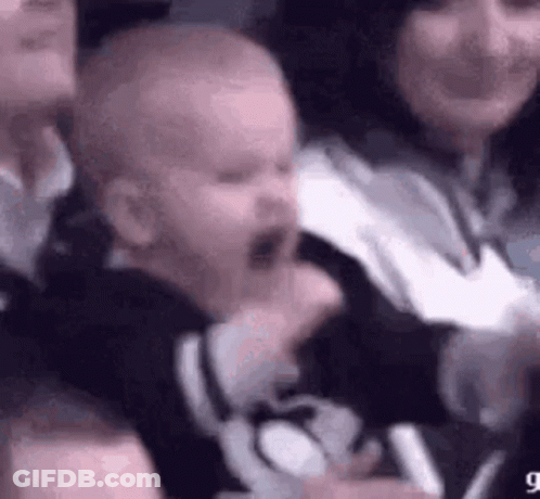 A Baby Is Crying In A Crowd Of People While Sitting In A Stadium . GIF
