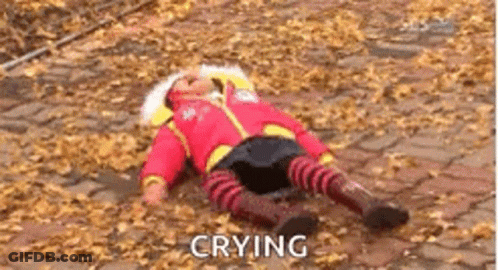 A Baby Is Crying While Laying On The Ground With Leaves . GIF