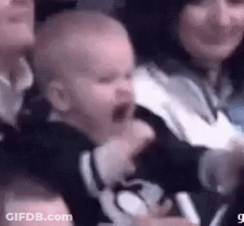 A Baby Is Crying While Sitting In A Crowd Of People . GIF