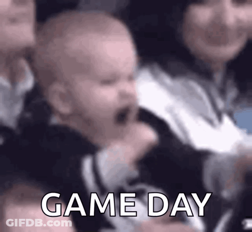 A Baby Is Crying While Sitting In A Crowd Of People And The Words Game Day Are Visible . GIF