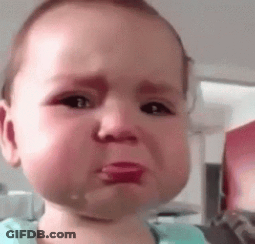 A Baby Is Crying With Tears Coming Out Of His Eyes And A Pacifier In His Mouth . GIF