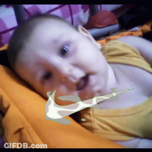 A Baby Is Laying On A Bed With A Nike Logo On Its Face GIF