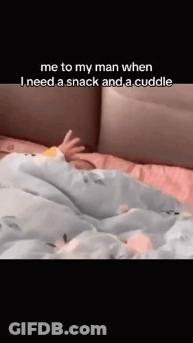 A Baby Is Laying On A Bed With The Caption " Me To My Man When I Need A Snack And A Cuddle " . GIF