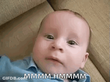 A Baby Is Laying On A Couch And Making A Funny Face While Looking At The Camera . GIF