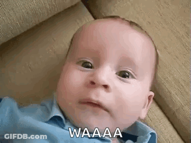 A Baby Is Laying On A Couch And Making A Funny Face While Looking At The Camera . GIF