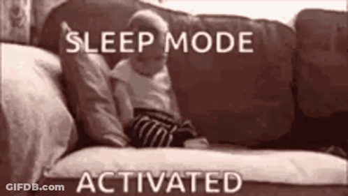 A Baby Is Laying On A Couch With The Words `` Sleep Mode Activated '' Above It . GIF