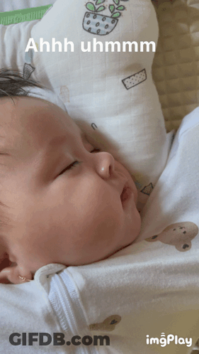 A Baby Is Laying On A Pillow With The Words Ahhh Uhmmm Written On It GIF