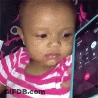 A Baby Is Looking At A Tablet Computer . GIF