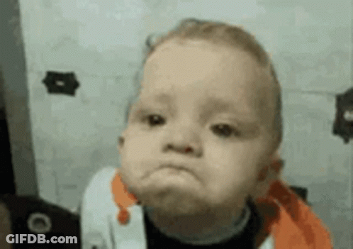 A Baby Is Making A Funny Face In Front Of A Wall . GIF