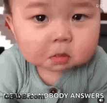 A Baby Is Making A Funny Face While Sitting Down And Says `` Me When Nobody Answers '' . GIF