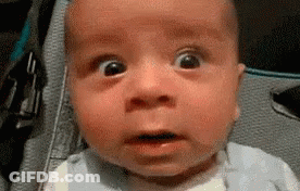 A Baby Is Making A Funny Face With His Mouth Open . GIF