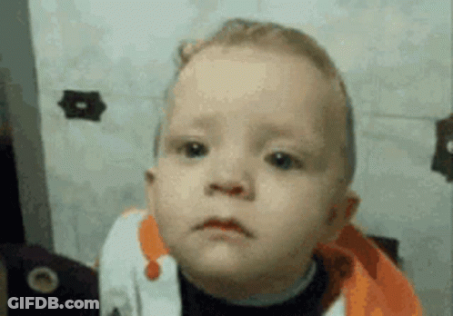 A Baby Is Making A Sad Face In Front Of A Mirror GIF