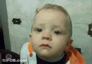 Baby With Bib Making Sad Face At Camera GIF