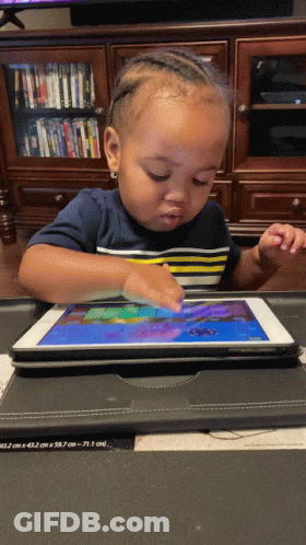 A Baby Is Playing On A Tablet With A Case On It GIF