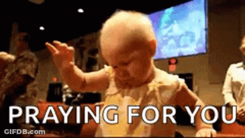 A Baby Is Praying For You While Sitting At A Table In A Church . GIF