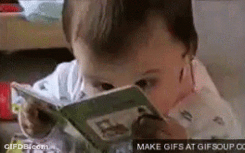 A Baby Is Reading A Book With A Magnifying Glass On His Face . GIF