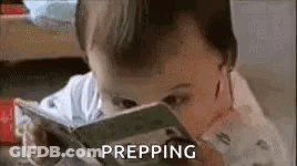 A Baby Is Reading A Book With The Word Prepping Written Next To Him . GIF