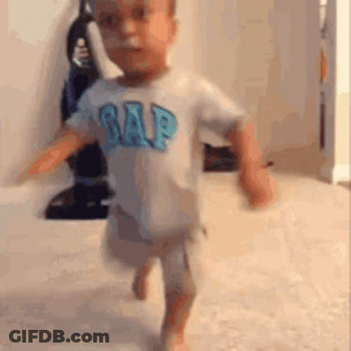 A Baby Is Running In A Room Wearing A Gap Shirt . GIF