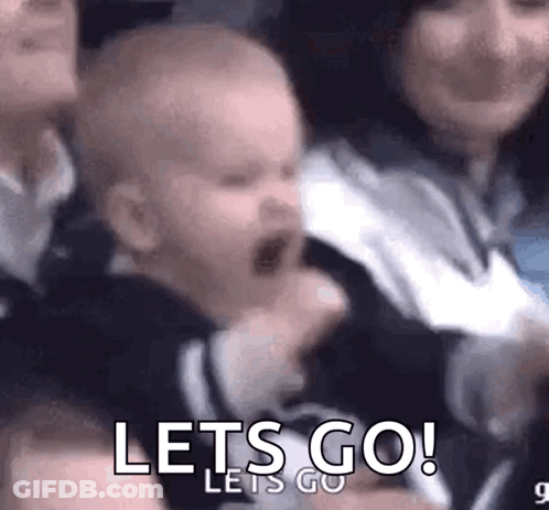 A Baby Is Screaming In A Crowd While A Woman Holds Him . GIF