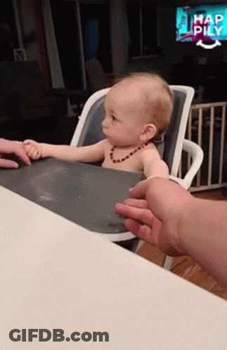 A Baby Is Sitting In A High Chair And Being Fed GIF