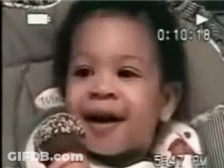A Baby Is Sitting In A High Chair Eating A Donut . GIF